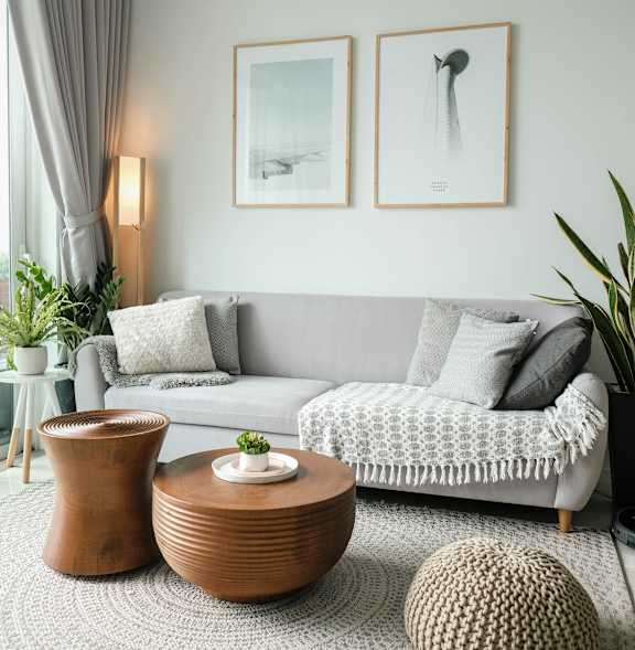 A round mirror hangs on a white wall above a wooden bed.
