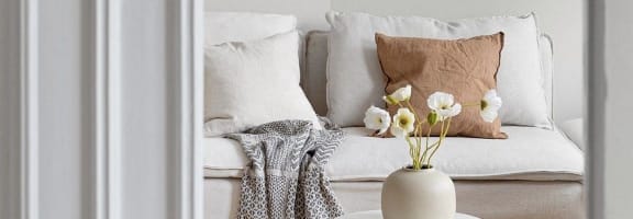 A view through a doorway into a living room with a couch and a coffee table.
