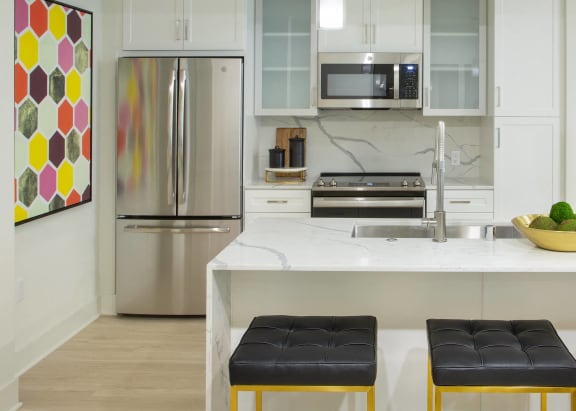 a kitchen with a large island with three stools in front of it