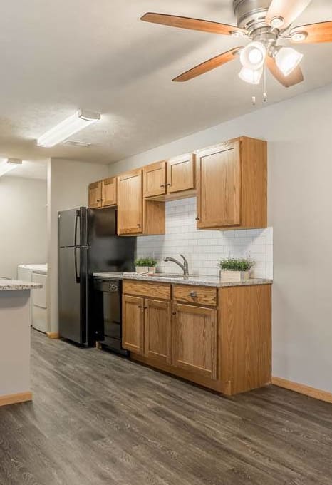 a kitchen and a living room with a ceiling fan