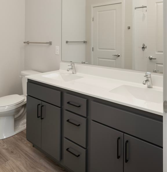 A bathroom with a white counter top and a white toilet.