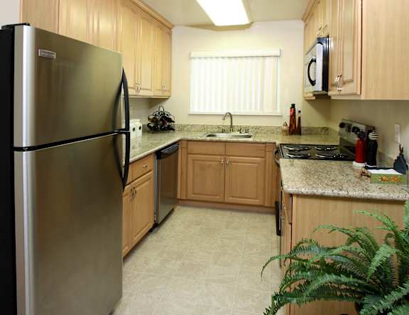 A kitchen with a refrigerator on the left and a microwave on the right.