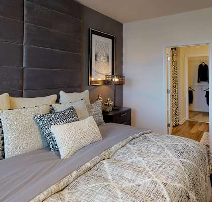 Bedroom with ceiling fan; window; door to in-room bathroom