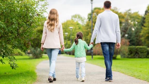 a family walking down a path in a park