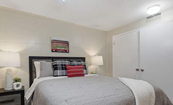 A bedroom with a bed, nightstand, and lamp.