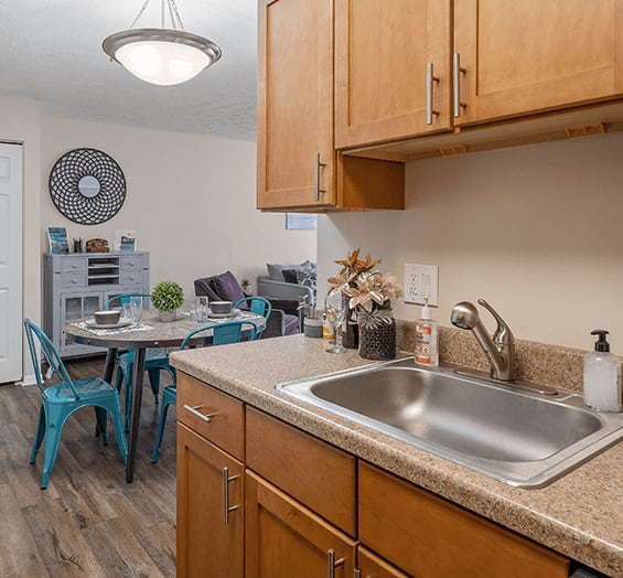 a kitchen with wooden cabinets and a stainless steel sink