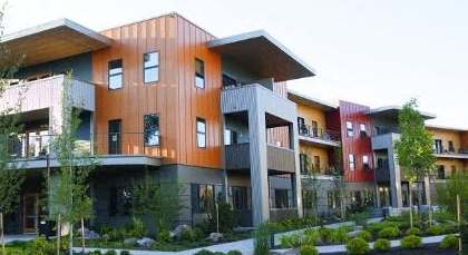 A modern building with a landscaped front yard.