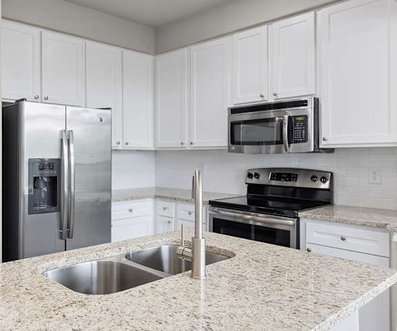 a kitchen with white cabinets and granite countertops at Waters Edge Apartment Homes, Georgetown, 78626