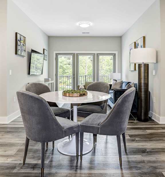 A dining room with a table and chairs.