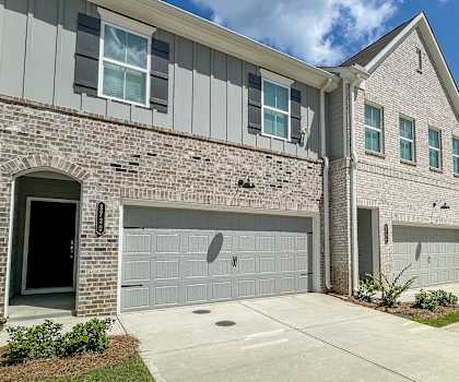 an exterior view of a brick house with a garage door