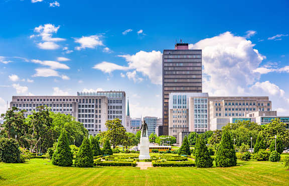 A large building with a tall white statue in front of it.