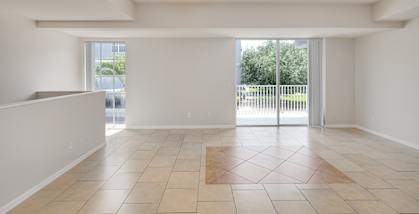 A spacious room with a ceiling fan and tiled flooring.