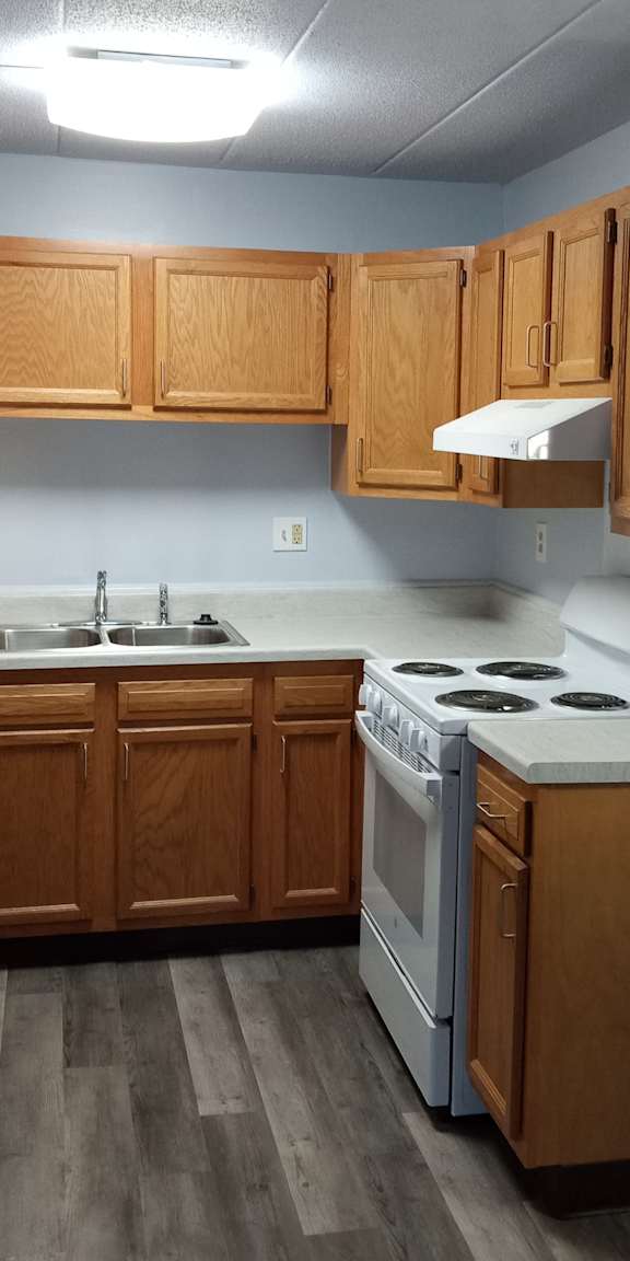a small kitchen with a refrigerator and wooden cabinets