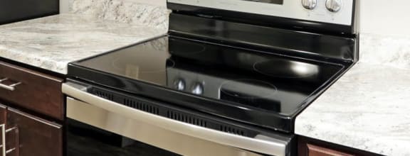 a kitchen with dark wood cabinets and white countertops