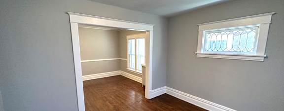 an empty room with hardwood floors and a window
