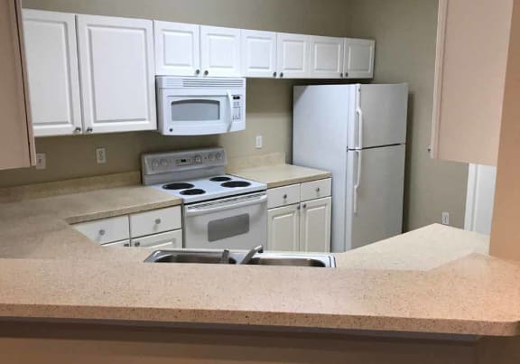 Kitchen With White Cabinetry at The Palms Club Orlando Apartments, Orlando, Florida