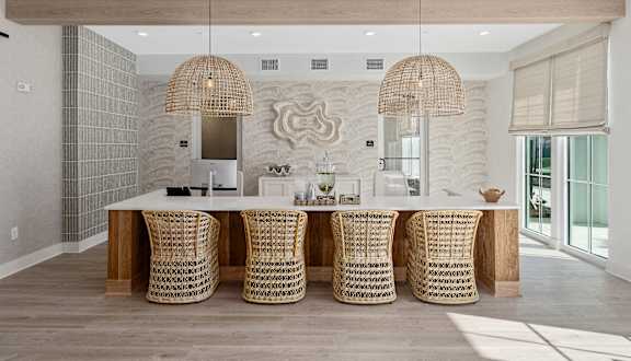 A dining room with a white table and chairs with a wooden top.