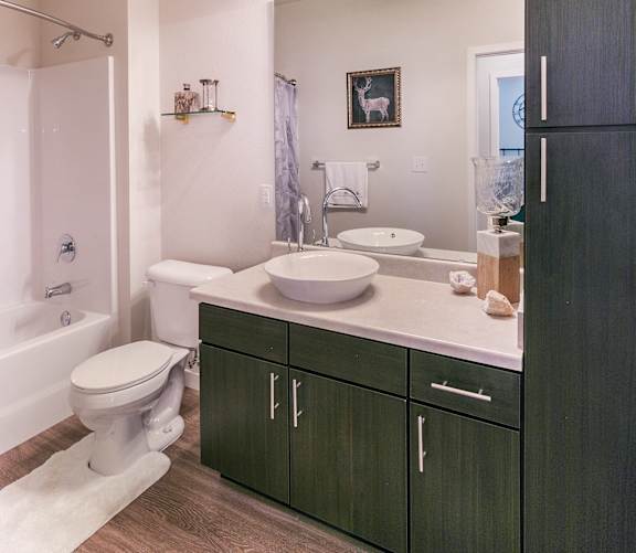 A bathroom with a toilet, sink, and a mirror.
