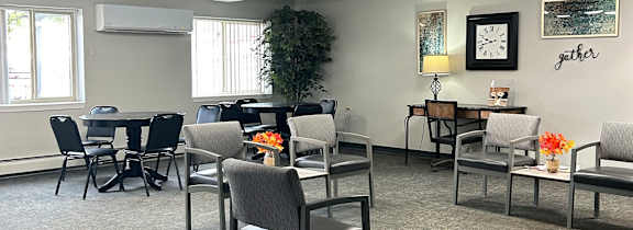 A room with grey chairs and tables.
