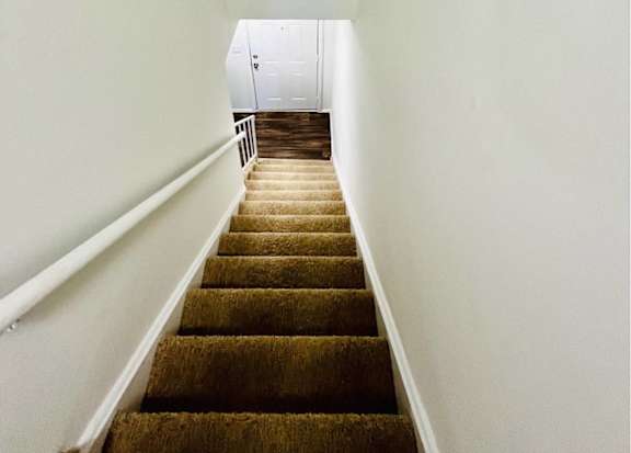 A staircase with a carpet at Twin City Townhomes, Winston-Salem, NC