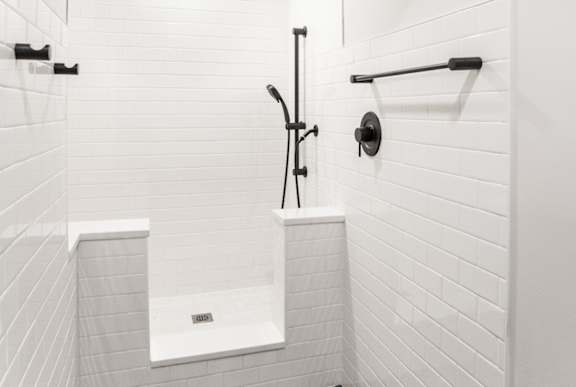 A white bathroom with a walk in shower.