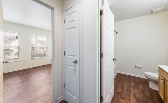 a bathroom with white doors and a toilet and a window at Horace Mann apartments and townhomes in Gary, IN