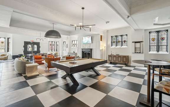 A black and white checkered floor in a room with a pool table.