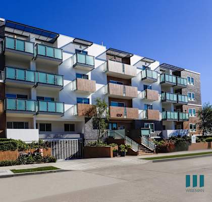 an exterior view of an apartment building on a sunny day