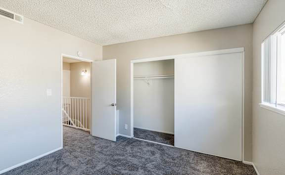 a bedroom with carpeted flooring and white walls