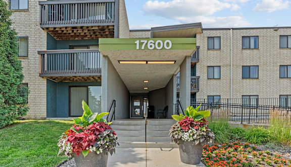 The entrance to apartment building 17600 with flower pots in front.