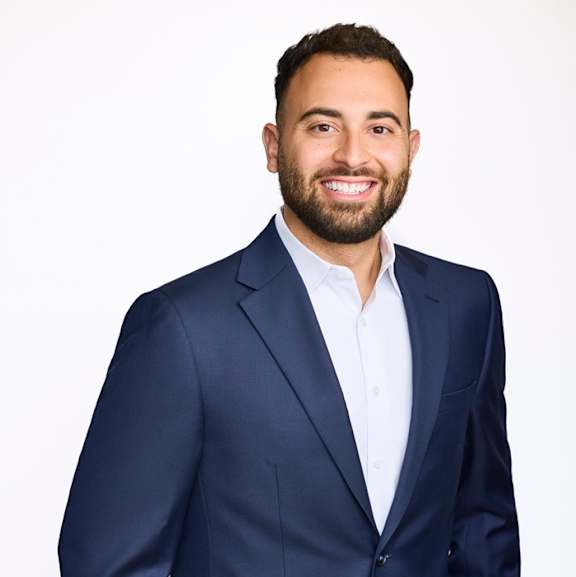 A man in a navy blue suit with a white shirt.