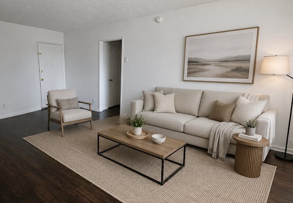A living room with a white couch, a coffee table, and a painting on the wall.