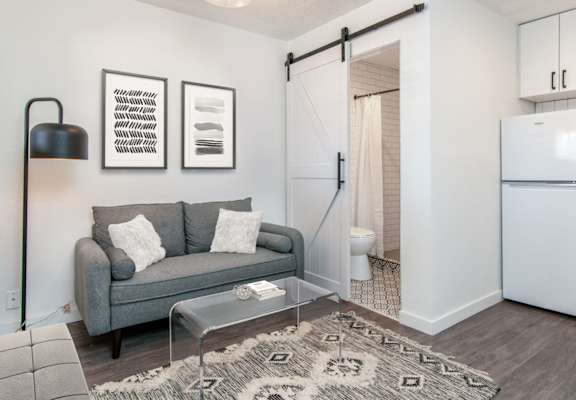 The Imperial Apartments Model Studio with Couch, Bathroom, and Kitchen