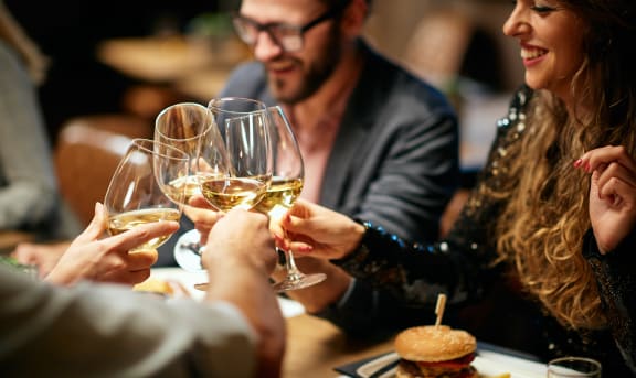 Similar Best friends sitting in restaurant for dinner and making a toast with white wine. On table is food.