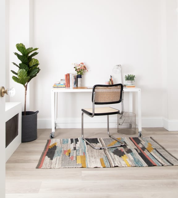 a home office with a desk and a rug on the floor