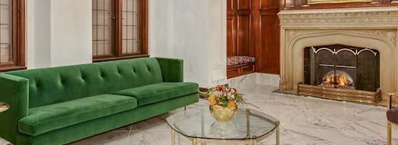 A large room with a green couch, a fireplace, and a coffee table.