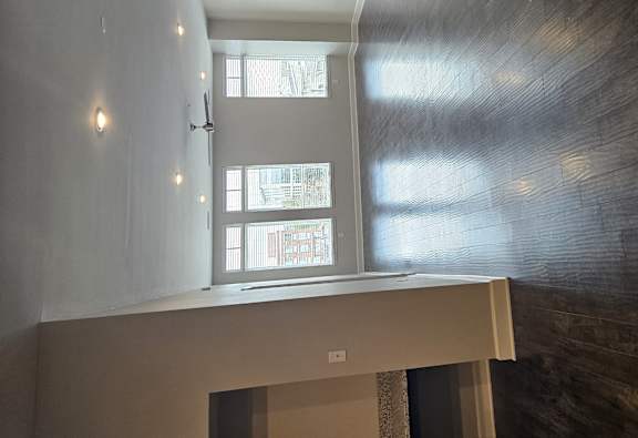 A room with a window and a wall with a wood grain pattern.