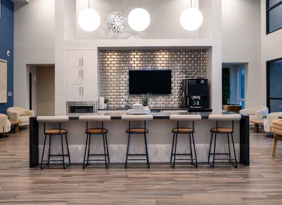 A modern kitchen with a bar area and a television above the fireplace.