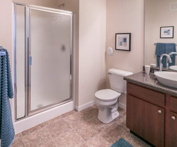 A bathroom with a toilet, sink, and shower.