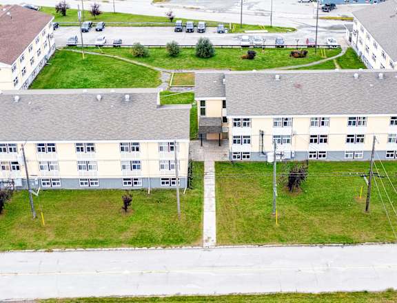 A large building complex with a parking lot in front.