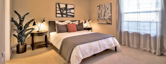Spacious bedroom with ceiling fan and large window at Rosemeade Apartments, Roseville, California