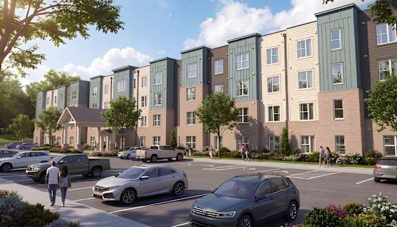 A row of modern townhouses with cars parked in front.