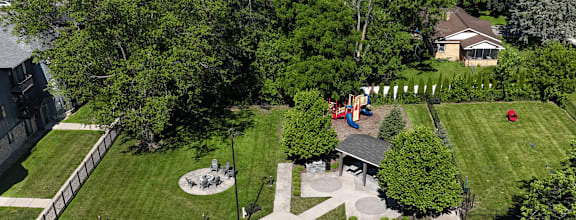 A swimming pool surrounded by a concrete patio and a green lawn.