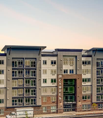 A modern apartment building with a green lawn in front.