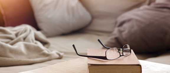 a book on a table with a bed in the background at Bedford Castle, Bedford Heights, 44146