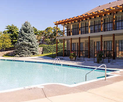 A refreshing swimming pool at Regent’s Walk Apartment Homes, surrounded by lounge chairs and greenery.