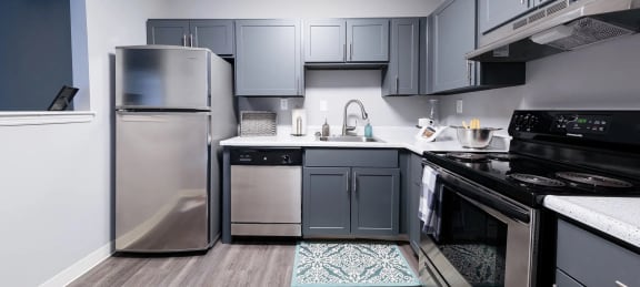 a kitchen with stainless steel appliances and dark cabinets