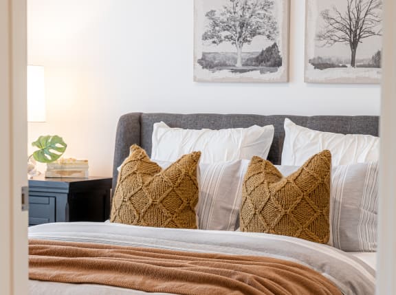 a bedroom with a bed and pillows and pictures on the wall