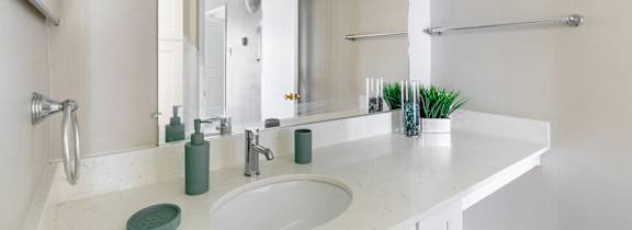 A bathroom with a white sink and green soap dish.