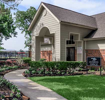A house with a well-maintained lawn and a walkway in front.